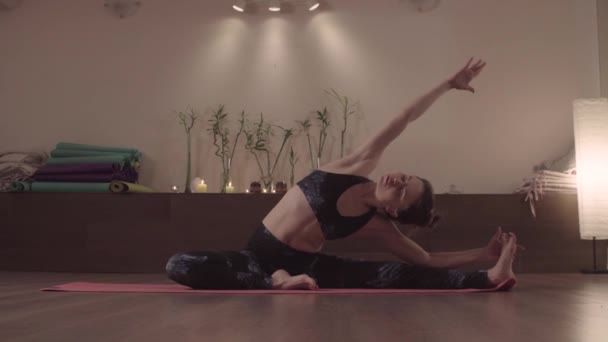 Приваблива жінка практикує йогу в гарній студії — стокове відео