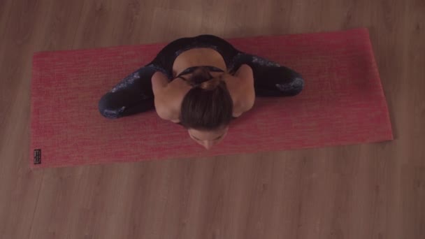 Wanita fleksibel melakukan latihan yoga di dalam ruangan — Stok Video