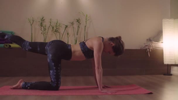 Junge Frau macht Yoga-Übungen im hellen Studio — Stockvideo