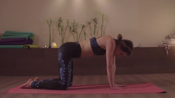 Ung kvinna gör yogaövningar i ljus studio — Stockvideo