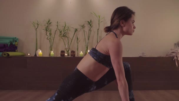 Молодая гибкая женщина, практикующая йогу в помещении — стоковое видео