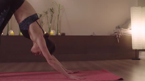 Evde yoga yapan esnek genç bir kadın. — Stok video