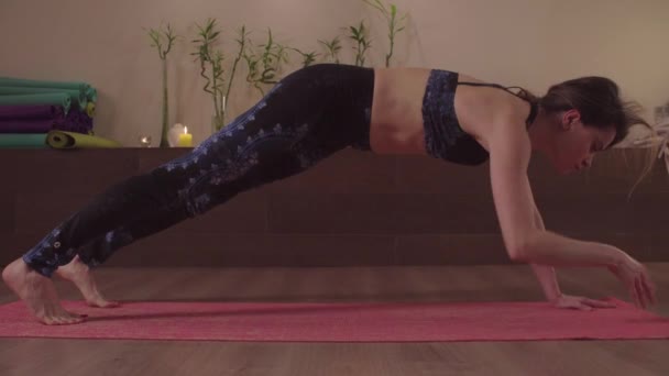 Joven mujer flexible practicando yoga en interiores — Vídeos de Stock