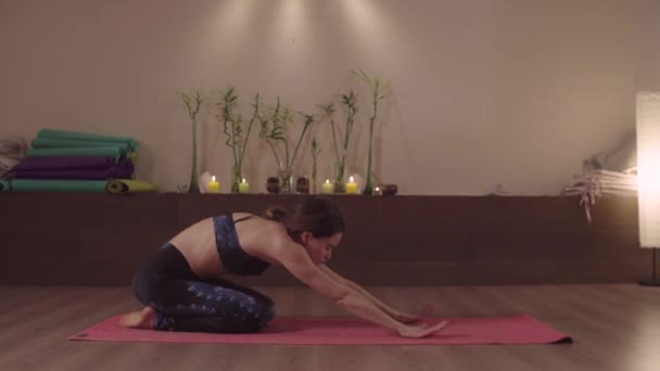 Młoda kobieta robi ćwiczenia jogi w jasnym studio — Wideo stockowe