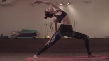 Güzel stüdyoda yoga egzersizleri yapan çekici kadın