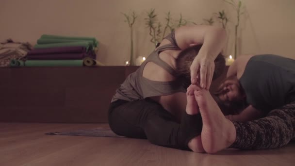 Yoga en pareja. Dos mujeres haciendo asanas de yoga en pareja — Vídeo de stock