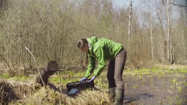 Ecoloog in het bos zet de kaart in gereedschapskist — Stockvideo