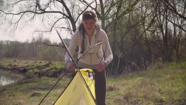 Mulher a montar uma tenda turística na floresta — Vídeo de Stock