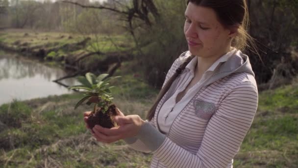 Joven voluntaria con el pequeño árbol en sus manos — Vídeos de Stock