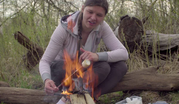 Mladá žena pečení marshmallows — Stock fotografie