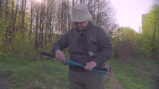 Äldre aktiv kvinna med vandringsstavar — Stockvideo