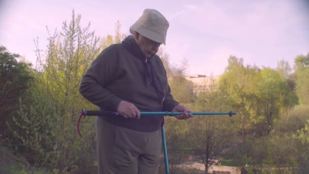 Trekking direkleri ile yaşlı aktif kadın — Stok video