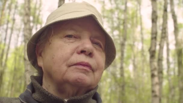 Porträt einer Seniorin gegen Wald - Powder Kamera — Stockvideo