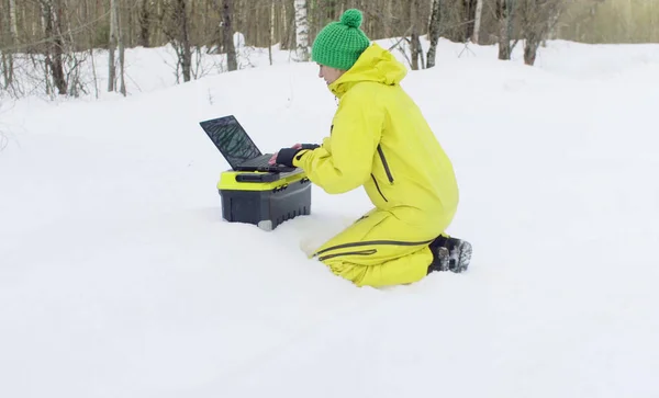 Ekolog pracujący na laptopie w zimowym lesie — Zdjęcie stockowe