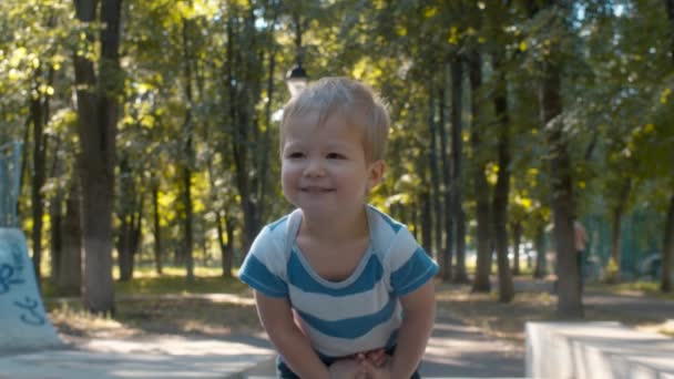 Petit garçon timide et souriant. Enfant dans le parc — Video