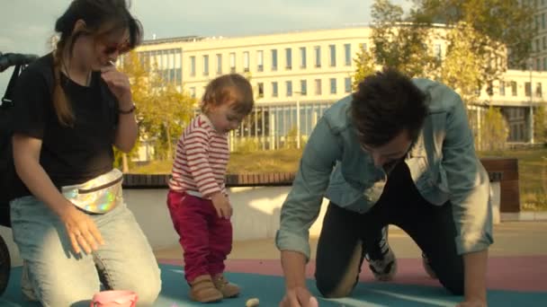 Papa trekt met krijt op de speelplaats — Stockvideo