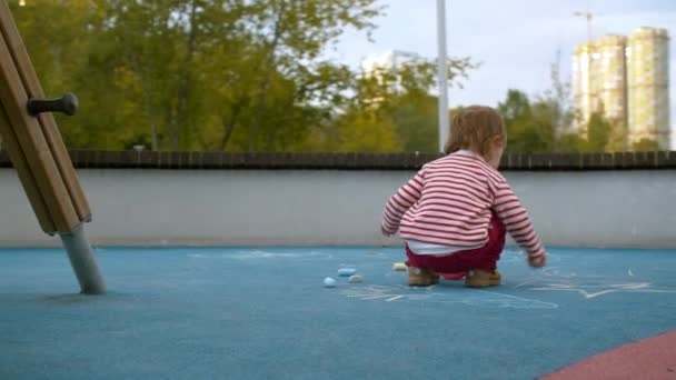 Маленькая девочка мелом на детской площадке — стоковое видео
