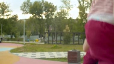 Yakışıklı anne bir salıncak üzerinde küçük kızı iterek