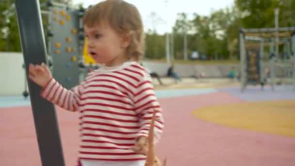 Zeer actief klein meisje op de speelplaats — Stockvideo