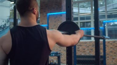 Bodybuilder barbell üzerinde ağırlık koyarak
