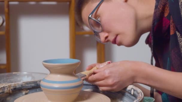 Pintura de un jarrón en una rueda de cerámica — Vídeos de Stock