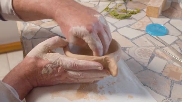 Mans handen beeldhouwen de klei pot — Stockvideo