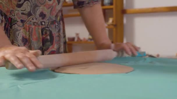 Senior female potter rolls clay like a dough — Stock Video