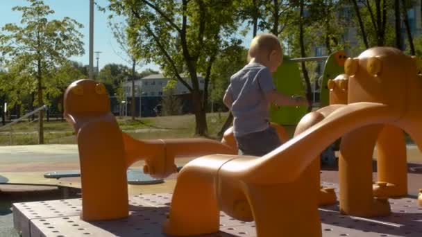 Bébé garçon sur l'aire de jeux — Video