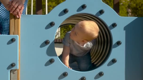 Baby boy crawls in the tube — Stock Video