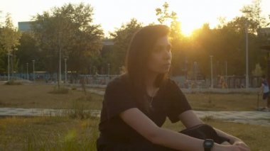 Parkta oturan genç dalgın kadın