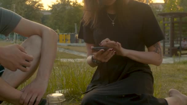 Νεαρή γυναίκα με κινητό τηλέφωνο στο πάρκο — Αρχείο Βίντεο