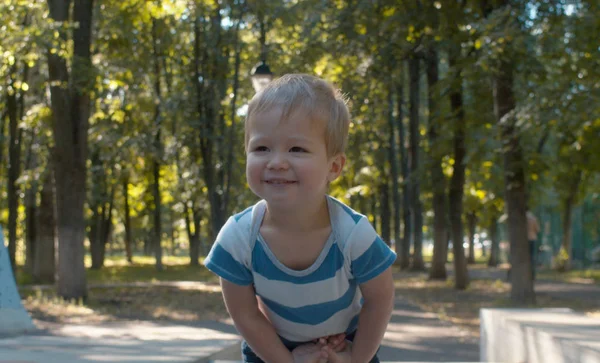 Félénk és mosolygó baba fiú. Gyerek a parkban — Stock Fotó