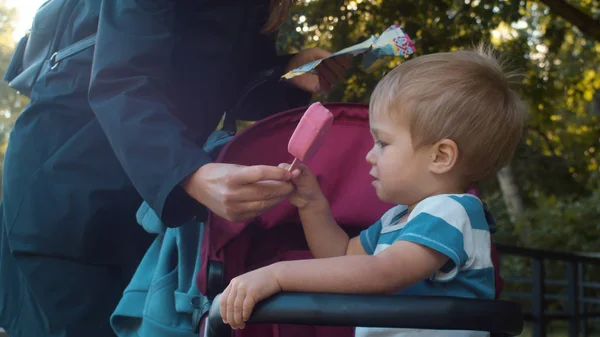 Mom giving ice cream to her son