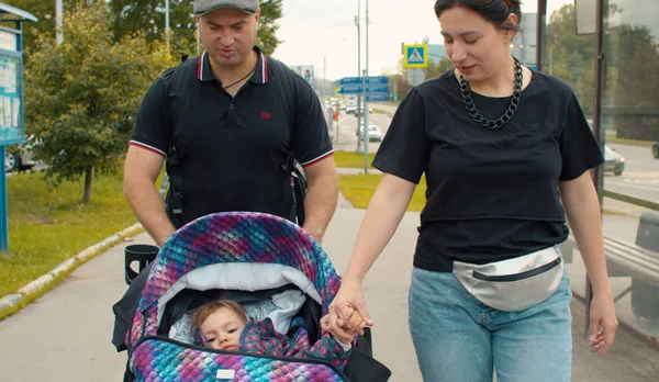 Mamá y papá caminando con la pequeña hija — Foto de Stock