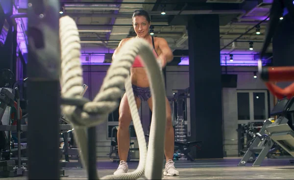 Сильна жіноча спортсменка тренується за допомогою бойових мотузок — стокове фото