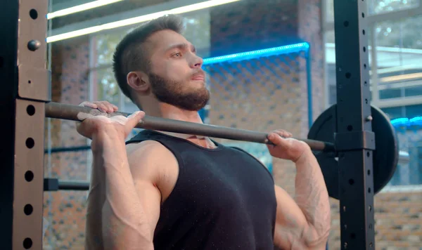 El atleta masculino levantando la barra en el gimnasio — Foto de Stock