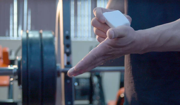 Vücut geliştirmeci ellerini tebeşirle. Antrenmanın başlaması