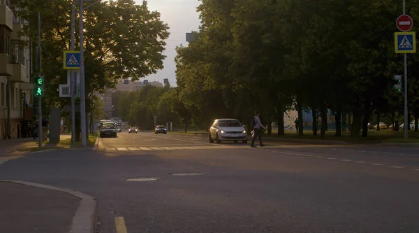 Crosswalk bij zonsondergang. Auto's op straat — Stockfoto