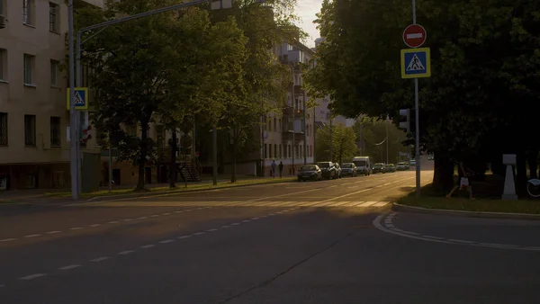 Crosswalk bij zonsondergang. Auto's op straat — Stockfoto