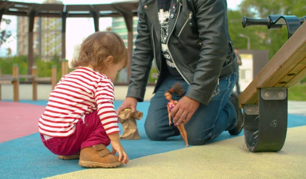 Hooligan father playing with daughter in the park