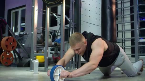 Чоловік-спортсмен виконує вправи з колесом ab — стокове відео