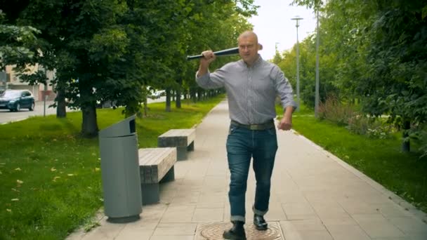 Delincuente caminando por la ciudad con un bate de béisbol — Vídeos de Stock