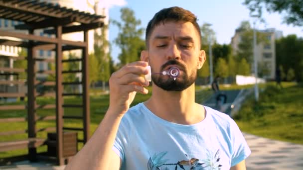 Adult Relaxed Man Blowing Soap Bubbles Summer Day Park — Stock Video
