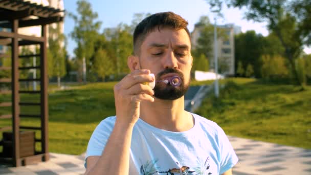 Ενήλικας Χαλαρός Άνθρωπος Φυσάει Φυσαλίδες Σαπούνι Καλοκαιρινή Μέρα Στο Πάρκο — Αρχείο Βίντεο