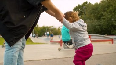 Anne bir paten üzerinde duran bebek yardım