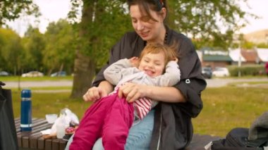 Anne bebeğe pantolon giyiyor