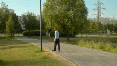 Parkta bir ayağı inceleyen işadamı