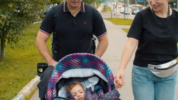 Mamá y papá caminando con la pequeña hija — Vídeos de Stock