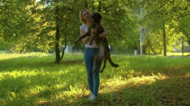 Красивая девушка с собакой в парке — стоковое видео