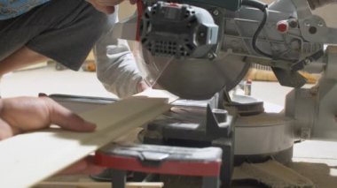 Bir tahta kesmek için dairesel testere kullanarak bina işçisi
